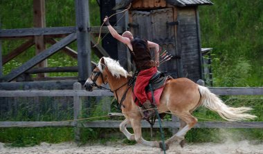Kiev, Ukraine June 19, 2021: Horse rider shoots a bow at a target in an old outfit - show in the entertainment complex Kievskaya Rus