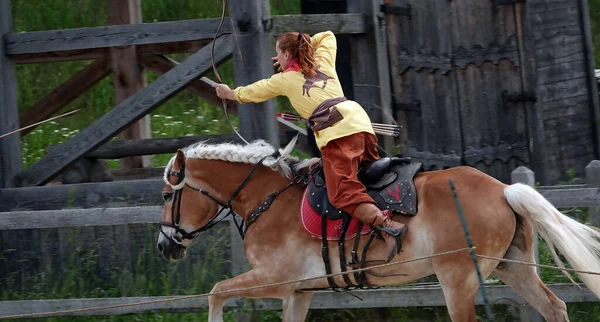 Kiev, Ukraine June 19, 2021: Horse rider shoots a bow at a target in an old outfit - show in the entertainment complex Kievskaya Rus