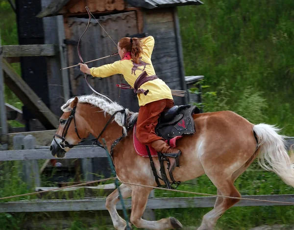 Kiev, Ukraine June 19, 2021: Horse rider shoots a bow at a target in an old outfit - show in the entertainment complex Kievskaya Rus
