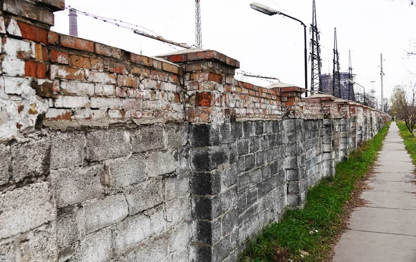 Old brick fence and footpath rippled with it
