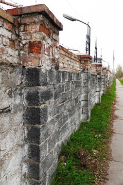 Old brick fence and footpath rippled with it