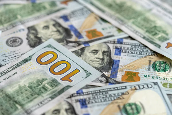 100 dolarlık banknotlar masanın üzerinde.