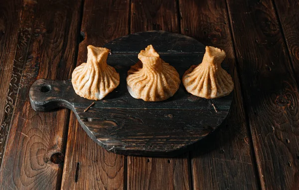 Tahta üzerinde et bulunan Gürcistan usulü kızarmış khinkali hamur tatlısı. Geleneksel bir Kafkas mutfağı yemeği..