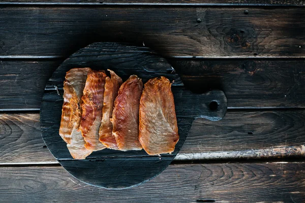 Сушеная курица, разрезанная на куски на деревянной доске — стоковое фото