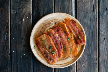 Kurutulmuş tavuk, kurutulmuş kümes hayvanları, ahşap arka planda bir tabakta şeritler halinde kesilmiş..
