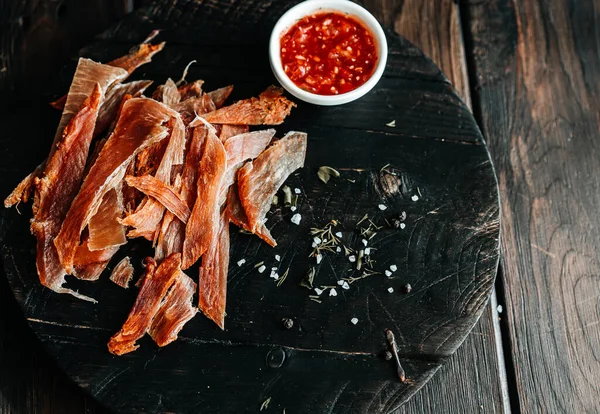 Sušené kuře nakrájené na proužky na dřevěnou desku se solí, pepřem, sousedící, kečupem — Stock fotografie