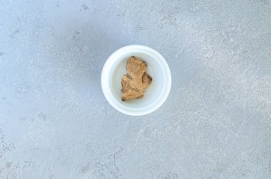 Gri arka planda, beyaz tabakta zencefil.