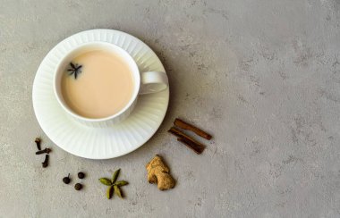 Hint çayı masala chai. Baharatlı Chai Masala çayı. Gri arka planda süt ve baharatlar..