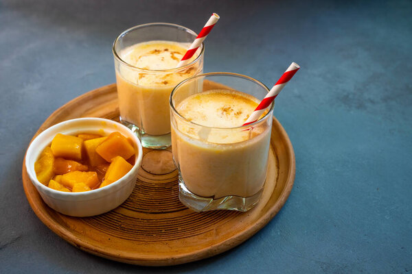 Yellow Indian mango yoghurt drink Mango Lassi or smoothie with turmeric and saffron. 