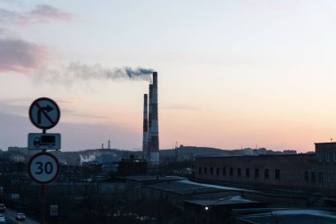 Bacadan duman çıkıyor. Bir apartmanın üstündeki şehirde sis var. Hava kalitesi problemi. Kirlilik. Yüksek kalite fotoğraf