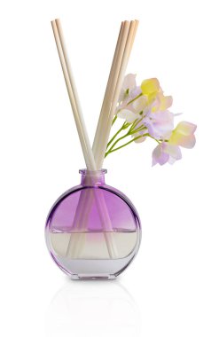 Evaporative aroma diffuser with wooden sticks in violet round glass bottle with flowers filled with essential oil perfume used in aromatherapy or as air freshener isolated on white background clipart