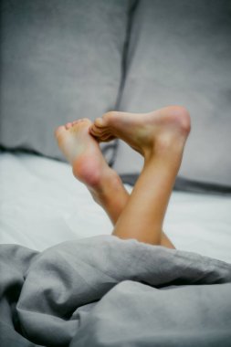 Bebek ayakları yatağın üzerinde, yakın plan.