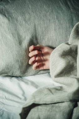 Elini battaniyenin altına koy.