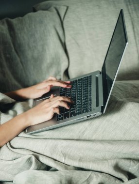 Yatakta dizüstü bilgisayarın arkasındaki adam.