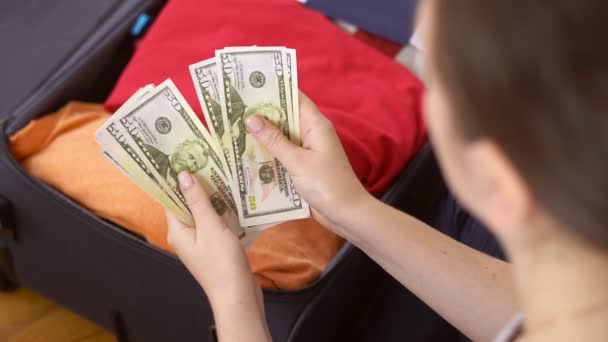 Mani femminili che contano banconote in dollari su sfondo valigia. Donna viaggiare dopo pensionanti aperti. — Video Stock
