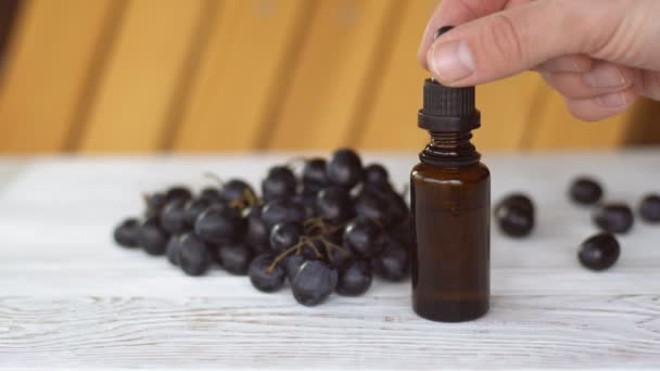 Aceite de semilla de uva natural goteando de la pipeta en botella, primer plano. Cosméticos biológicos. — Vídeo de stock