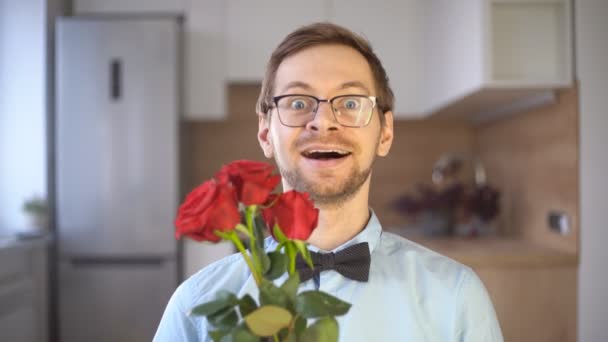 Passionate male nerd in glasses with bow tie holding red rose. — Stockvideo