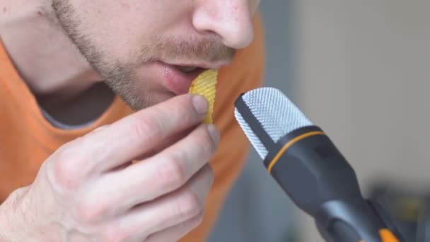 Homme barbu faisant des sons ASMR avec microphone manger des puces. Sons déclencheurs pour le stress et le soulagement des crises d'anxiété, bon sommeil. — Video