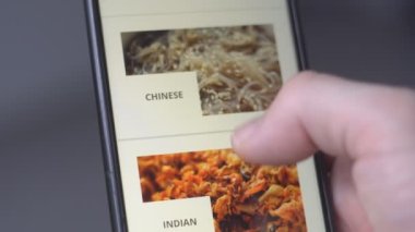 Çevrimiçi sipariş için ekranda Asya ve Meksika yemeklerini uygulamalı akıllı telefon kullanarak erkek ellerini kapat.