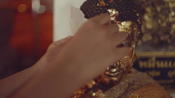Hand Eines Buddhistischen Mädchens Trägt Blattgold Auf Buddha Statue Auf — Stockvideo