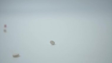 Tıbbi haplar beyaz arka plana düşüyor..