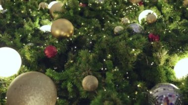 Parlak ışıklarla süslenmiş çelenklerle süslü Noel ağacı.