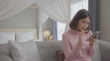 Rahat genç bir kadın akıllı telefon kullanarak sosyal medyada sörf yapıyor, haberleri kontrol ediyor, mobil oyunlar oynuyor ya da koltukta oturmuş mesaj yazıyor..