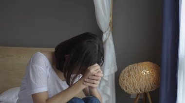 Üzgün, düşünceli, düşünceli genç bir kadın. Başını çevirmiş, sorunları düşünüyor. Evde tek başına oturuyor, mutsuz hissediyor..