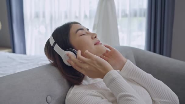 Kvinnan bär trådlösa hörlurar njuta av bra meditativ musik. Lugn ung kvinna i headset slappna av lyssna på ljudbok med slutna ögon. — Stockvideo