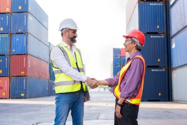 Foreman handshake engineer control loading Containers box from Cargo freight ship for import export. Freight containers in sea port.