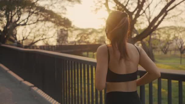 Frau Sportkleidung Mit Schutzmaske Joggt Bei Sonnenuntergang Auf Der Brücke — Stockvideo