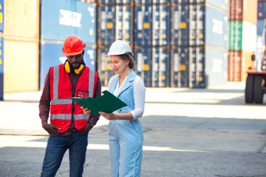 İş kadını ve mühendis ithalat için Kargo nakliye gemisinden yükleme konteynırları kutusunu konuşuyor ve kontrol ediyor. Rıhtımda nakliye.