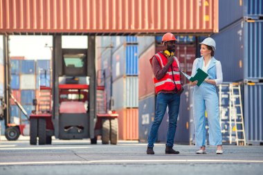 İş kadını ve mühendis ithalat için Kargo nakliye gemisinden yükleme konteynırları kutusunu konuşuyor ve kontrol ediyor. Rıhtımda nakliye.
