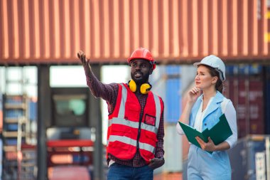 İş kadını ve mühendis ithalat için Kargo nakliye gemisinden yükleme konteynırları kutusunu konuşuyor ve kontrol ediyor. Rıhtımda nakliye.