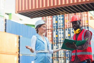 Kargo nakliye gemisinden ithalat için yük konteynırları kutusuyla konuşan işkadını ve mühendis sorunu. Rıhtımda nakliye.