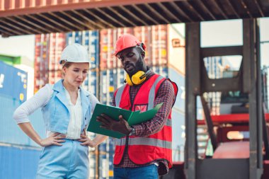 Kargo nakliye gemisinden ithalat için yük konteynırları kutusuyla konuşan işkadını ve mühendis sorunu. Rıhtımda nakliye.