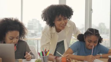 Öğrencileriyle birlikte modern sınıfta yazı dersi veren Afro-Amerikan bayan öğretmen..