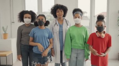 African American doctor and kids waving hand in the hospital or clinic.