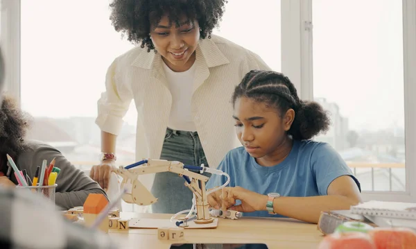 Classroom with diverse learners of happily African American students and teacher doing activities together. The teacher is teaching, guiding and talking to the children in diverse.