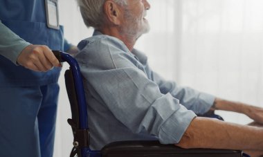 Nurse putting wheelchair with senior man  window. Unhappy senior man having geriatric or depression disease. Therapist taking care, giving support and empathy.