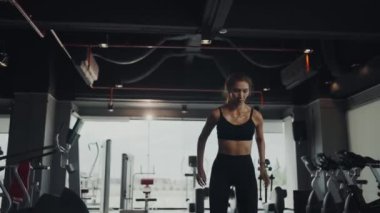 Young woman jumping on cube at gym. Healthy lifestyle, exercising at gym concept.