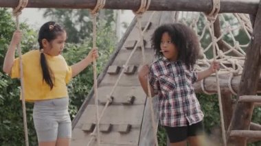 İki kız çocuk dışarıda salıncakta salıncakta oynuyorlar..