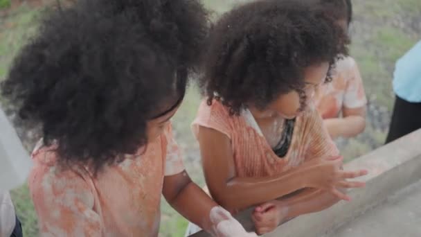 小组小亚洲和非洲裔美国女孩用她的手涂上颜色后 在室外洗脸盆用肥皂洗手 儿童卫生和健康概念 — 图库视频影像
