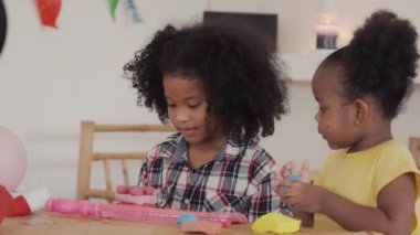 İki küçük Afrikalı Amerikalı çocuk birlikte oynamayı öğreniyor plasticin yontuyorlar farklı şekiller yaratıyorlar. Evde etkinlik, eğlence sanatı ve hobi konsepti.