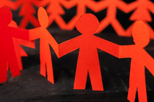 Equipo de muñecas de papel personas cogidas de la mano — Foto de Stock