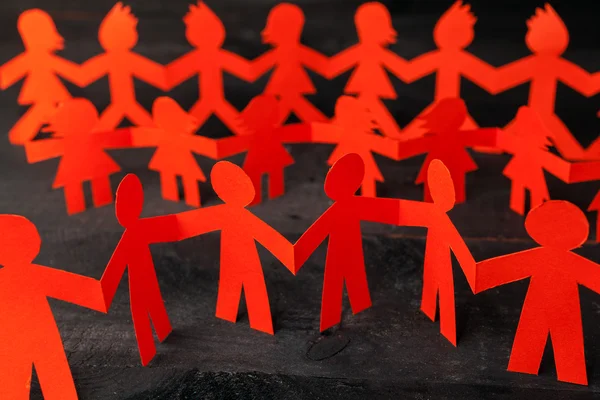 Team of paper doll people holding hands — Stock Photo, Image