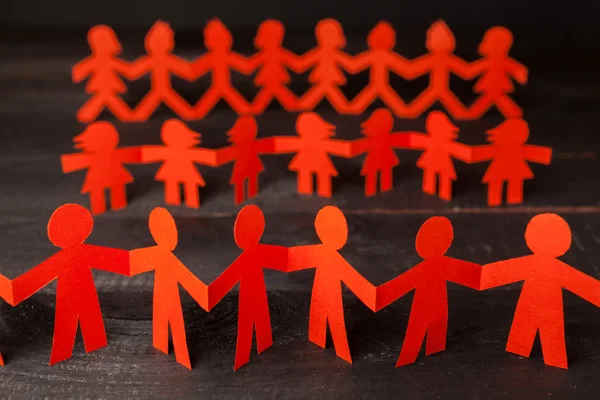 Team of paper doll people holding hands — Stock Photo, Image