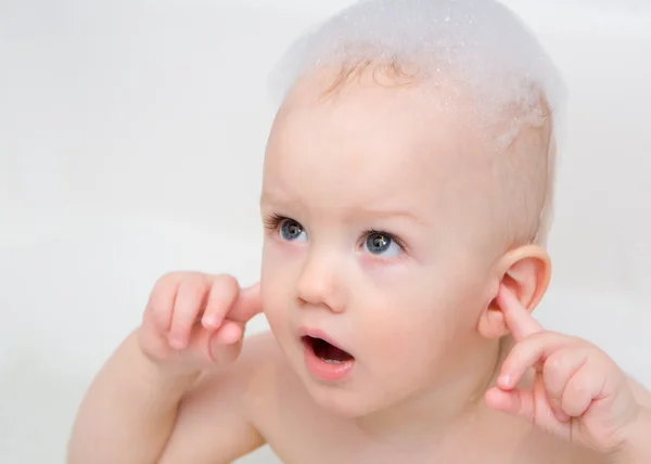Little boy having a bath with soap foam