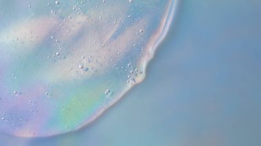 Holografik dokuda baloncuklu kozmetik jelin arka planı. Metin veya tasarım için alanı kopyala. Üst görünüm, antibakteriyel sıvı yüzey. Arka plan veya kozmetik modelleme kadar iyi, büyük pankart.