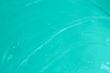 Mavi arka planda köpüklü jöle salladı. Kozmetik aromalı aloe vera ya da antibakteriyel jel sürmüş. Kopya alanı kadar iyi..